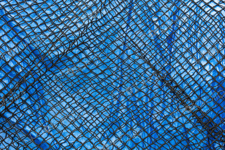 Detail of commercial fish net covering blue tarpaulin