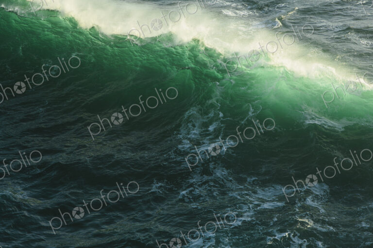 Detail of crashing waves, surf and crest, windblown mist curling from the white water,…