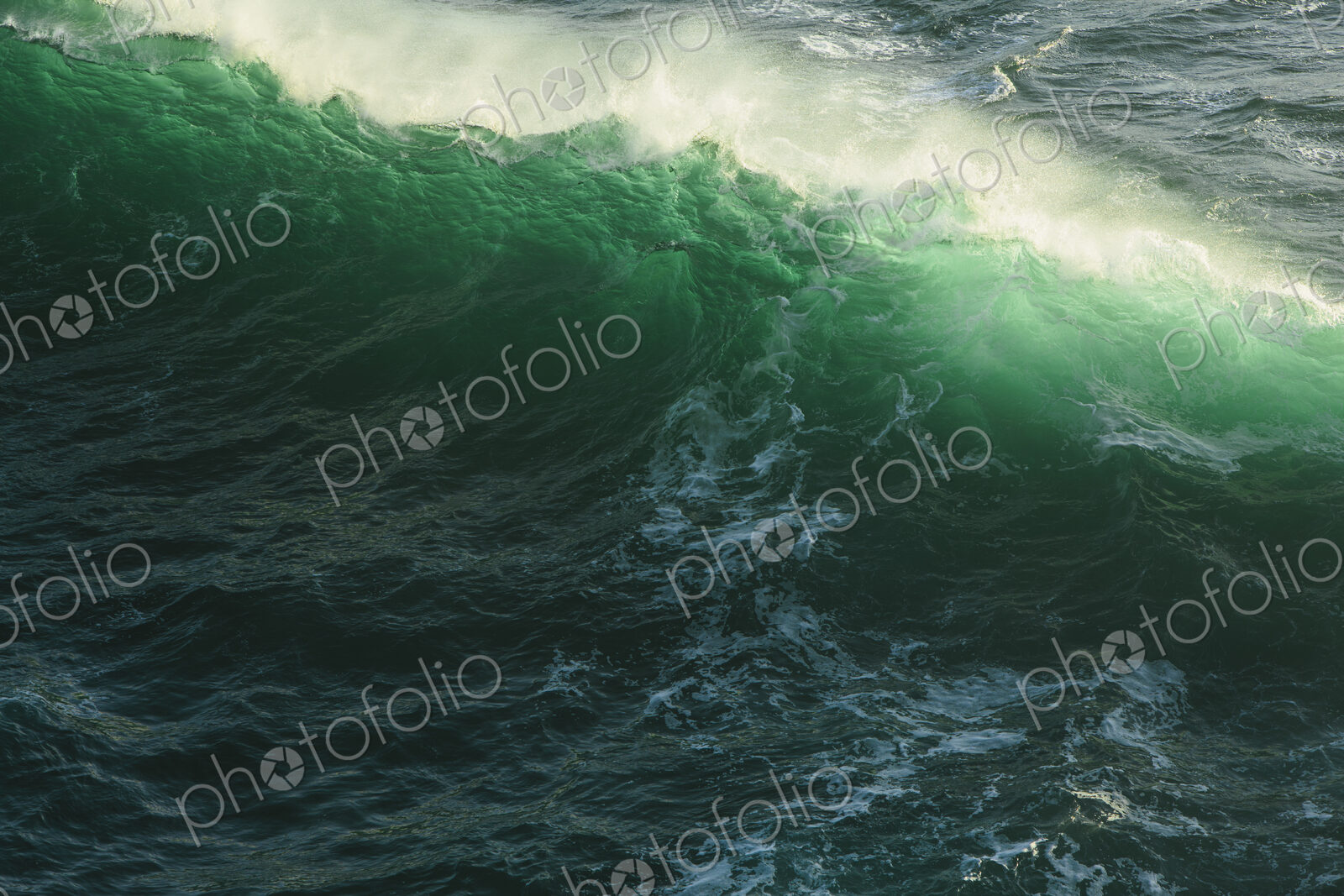 Detail of crashing waves, surf and crest, windblown mist curling from the white water,…