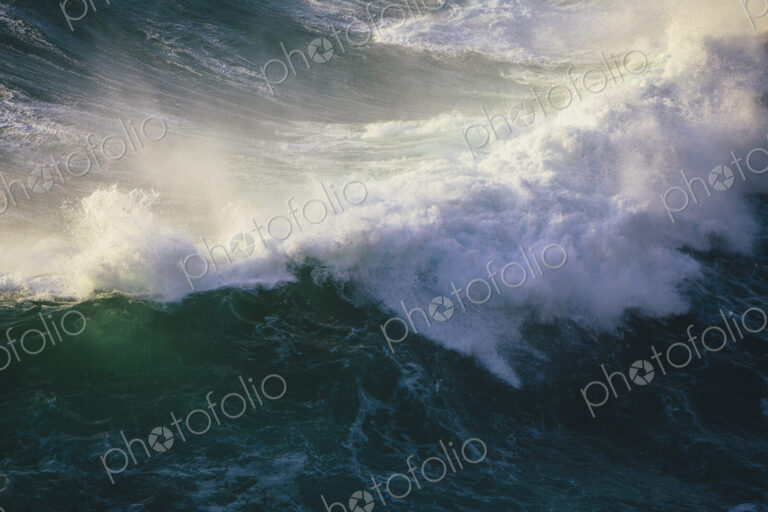 Detail of crashing waves, surf and crest, windblown mist curling from the white water,…