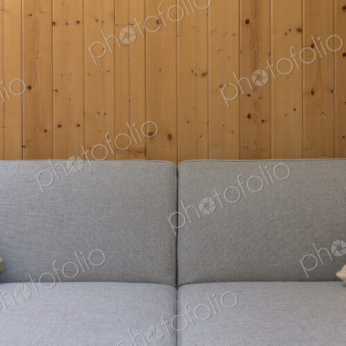 Detail of modern couch against wood panel wall Detail of modern couch against wood panel wall