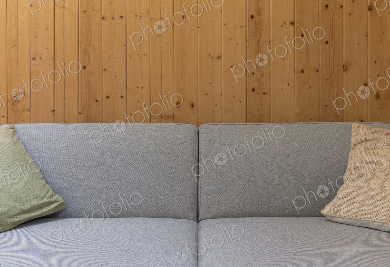 Detail of modern couch against wood panel wall