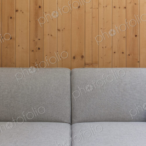Detail of modern couch against wood panel wall Detail of modern couch against wood panel wall