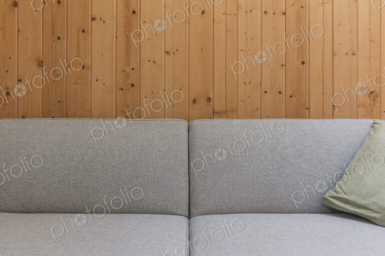 Detail of modern couch against wood panel wall