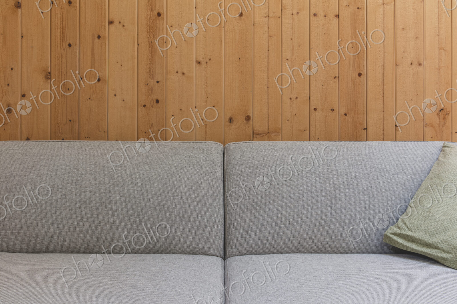 Detail of modern couch against wood panel wall