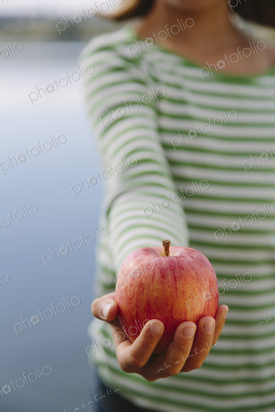 Detail of nine year old girl holding organic apple