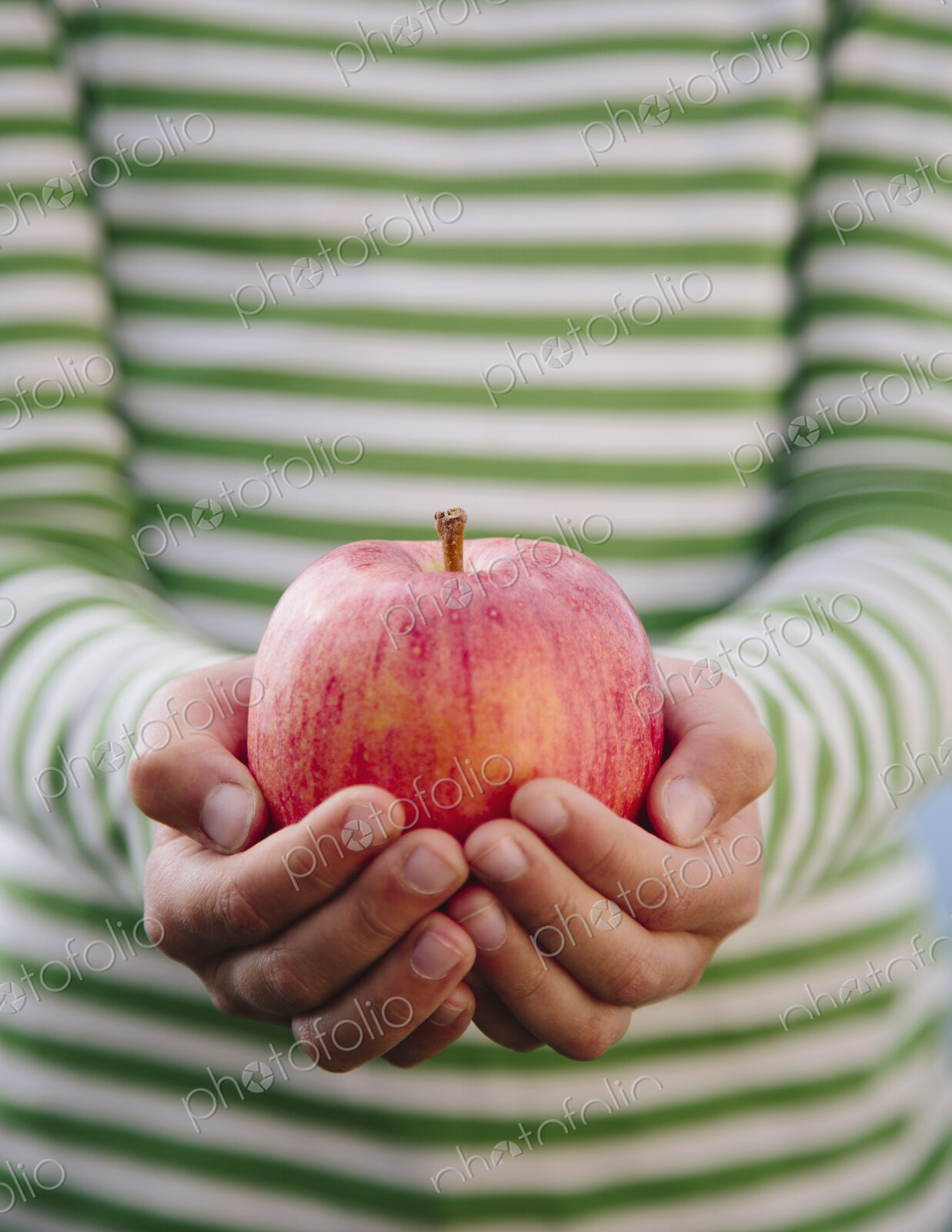 Detail of nine year old girl holding organic apple