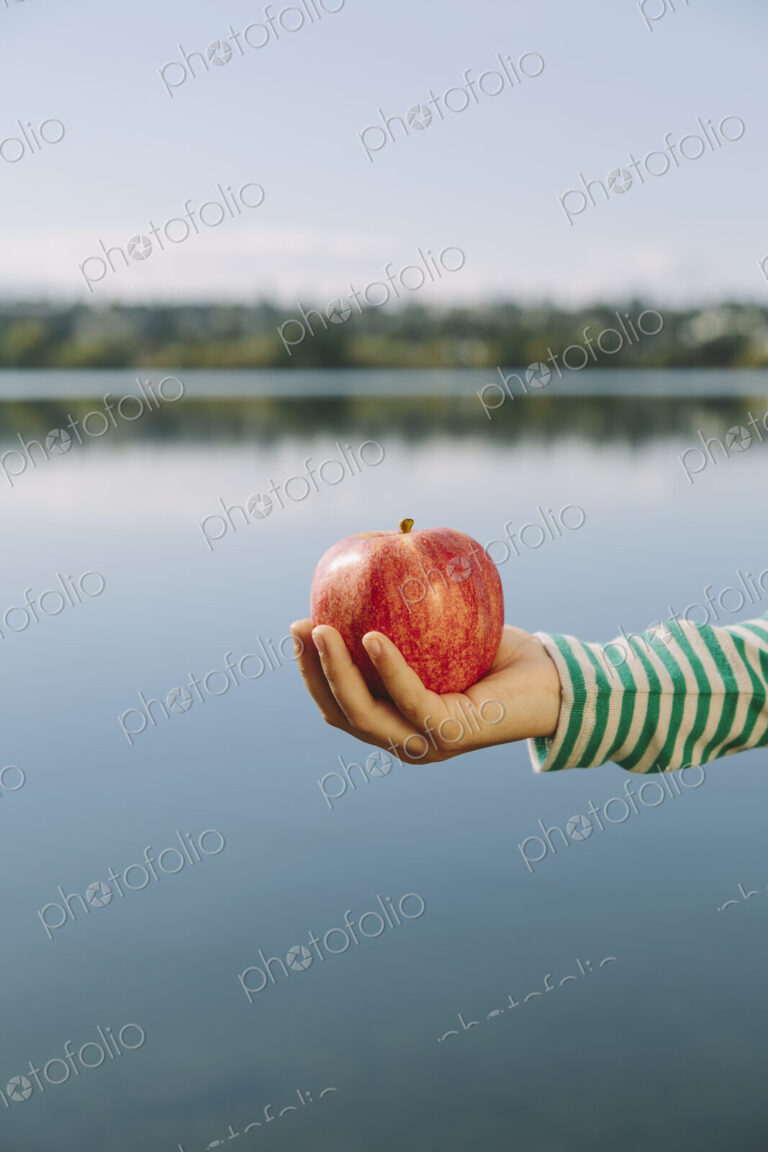 Detail of nine year old girl holding organic apple