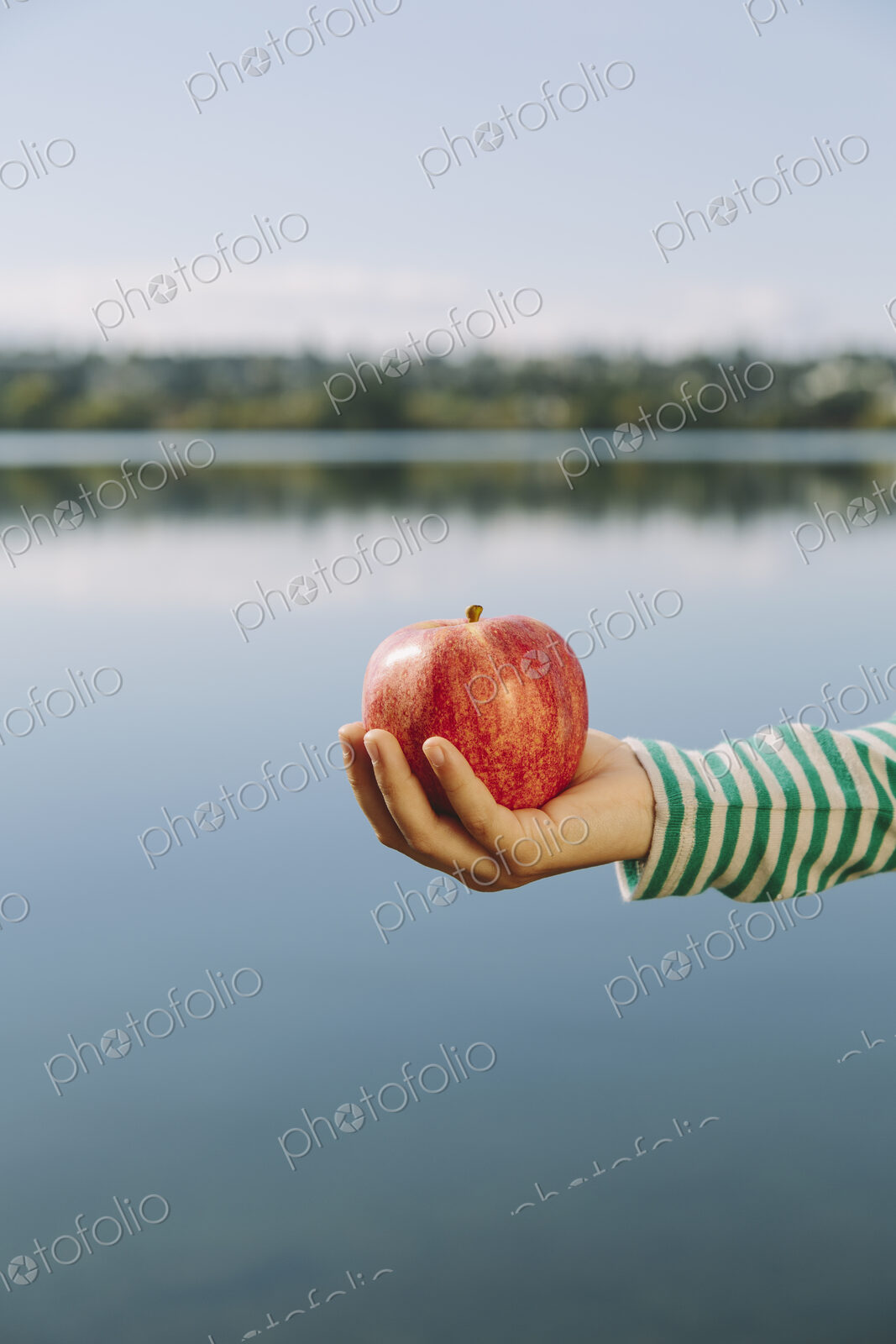 Detail of nine year old girl holding organic apple