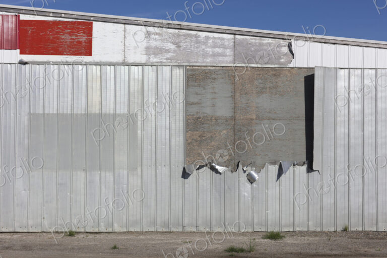 Detail of old warehouse, peeling metal on siding,