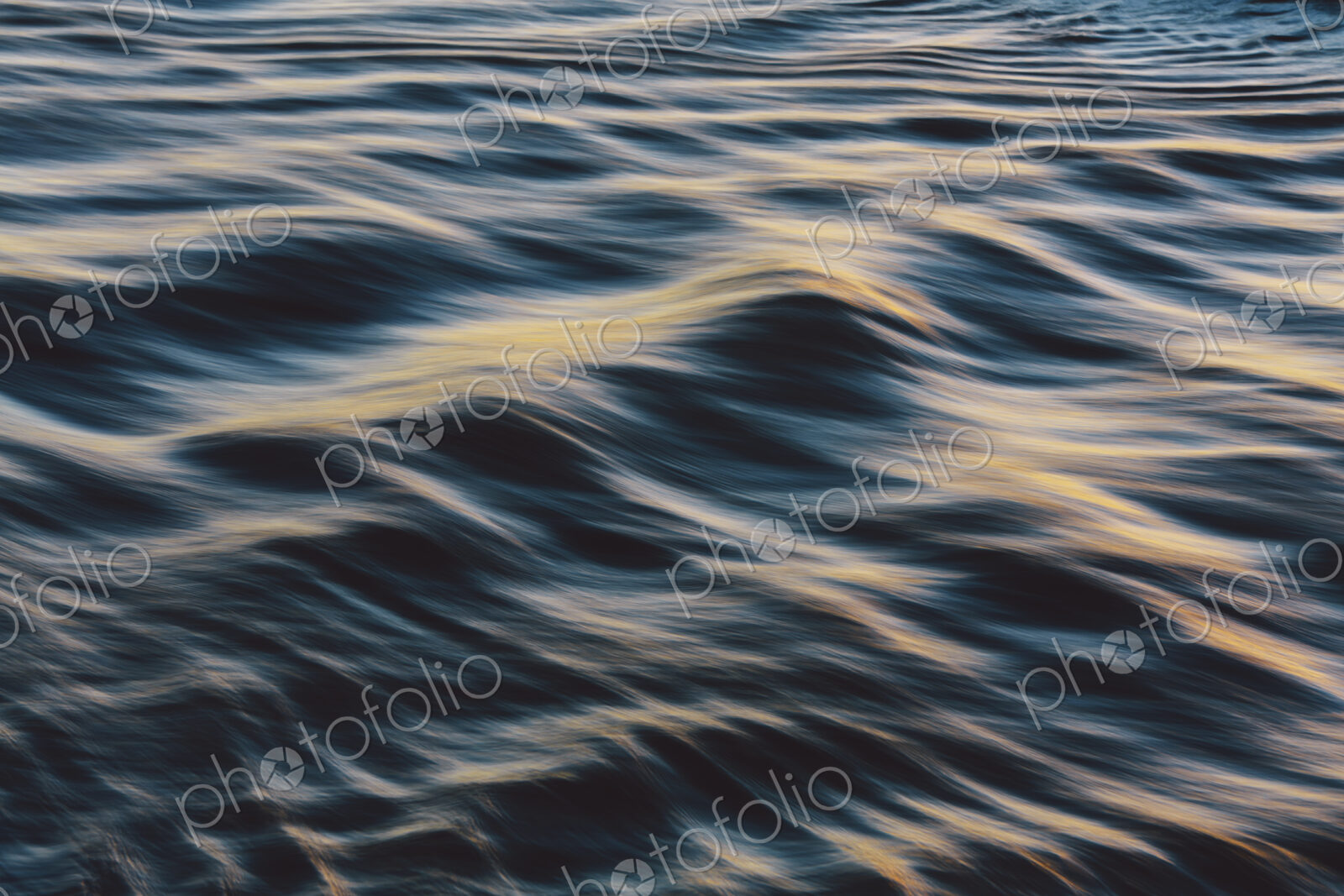 Detail of sunlight reflecting on small waves on the water surface offshore.