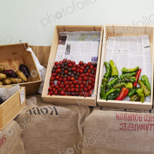 Detail of wooden crates with fresh vegetables in a farm shop. Detail of wooden crates with fresh vegetables in a farm shop.