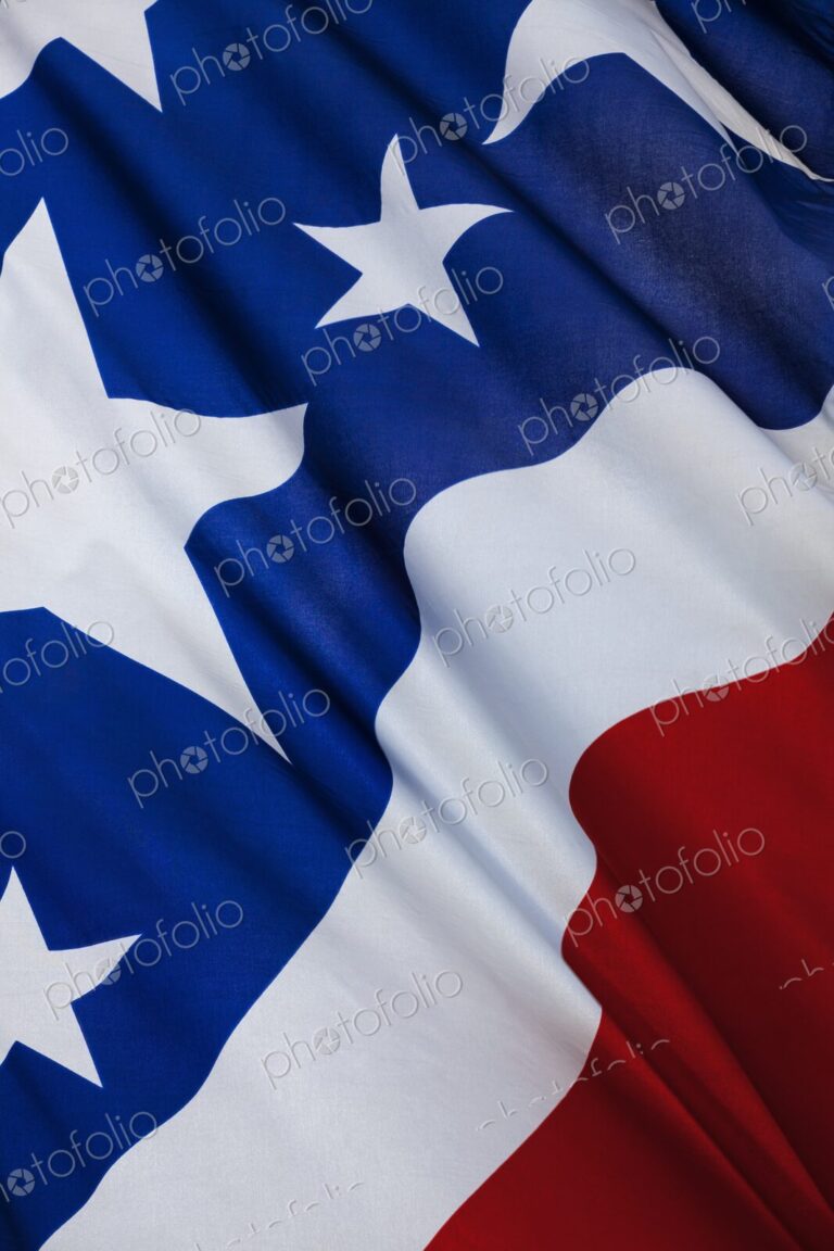 Detailed close-up of the United States flag showing stars and stripes in red, white,…