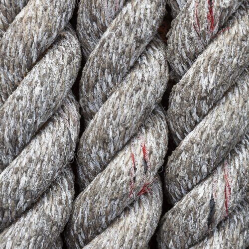 Detailed close-up of thick, weathered rope at a marina in Bandon, Oregon, showing… Detailed close-up of thick, weathered rope at a marina in Bandon, Oregon, showing…