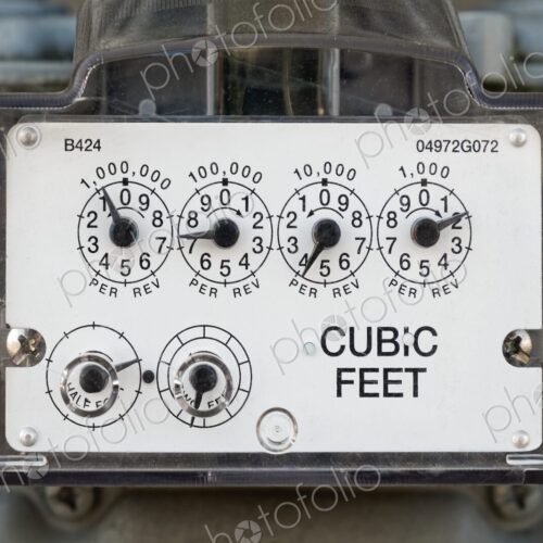 Detailed view of a natural gas meter with dials measuring cubic feet of gas usage for…