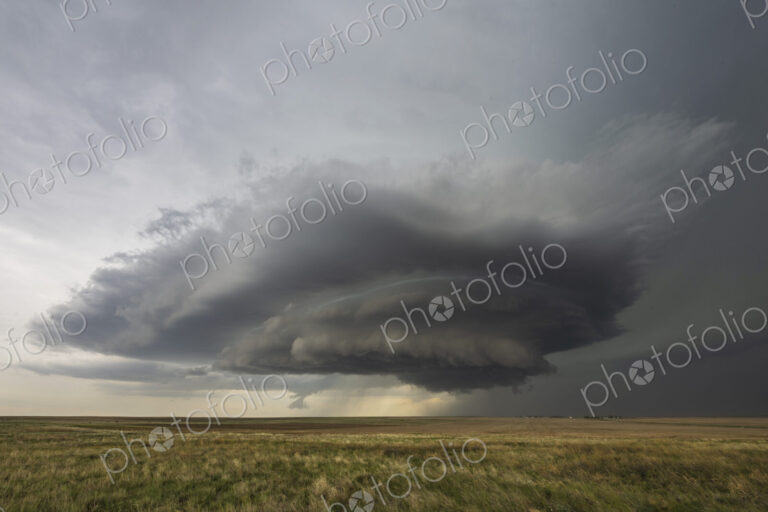 Developing Mesocyclone, a towering cloud shape above the horizon, fields.