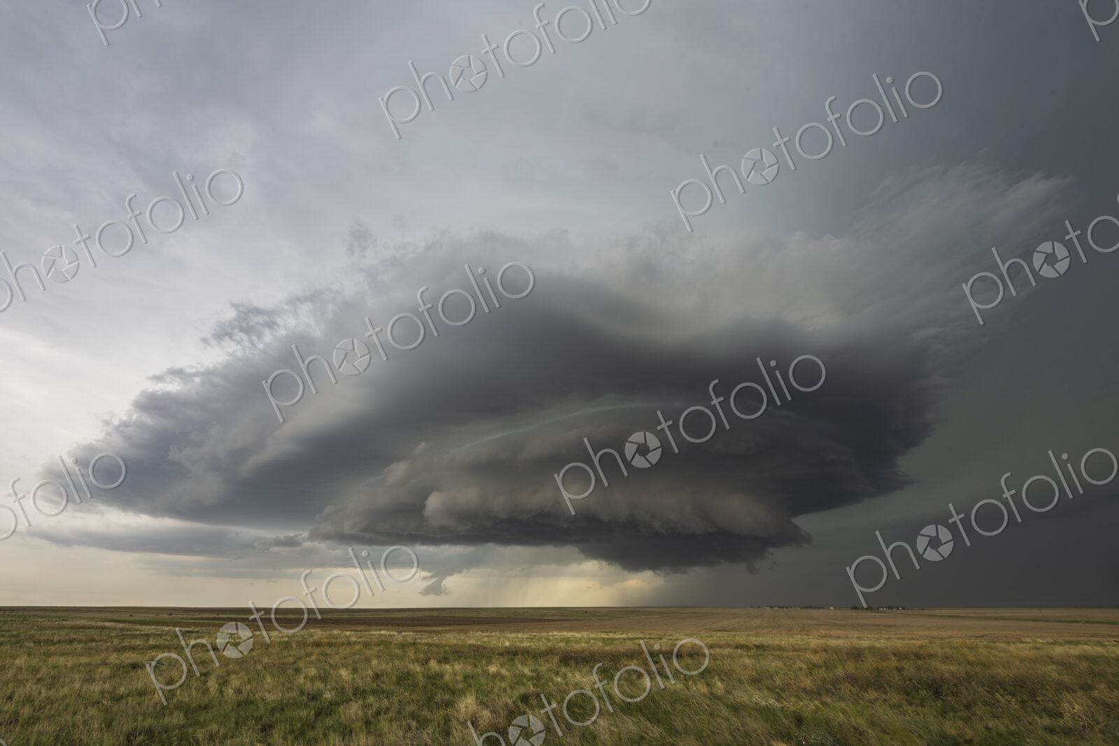 Developing Mesocyclone, a towering cloud shape above the horizon, fields.