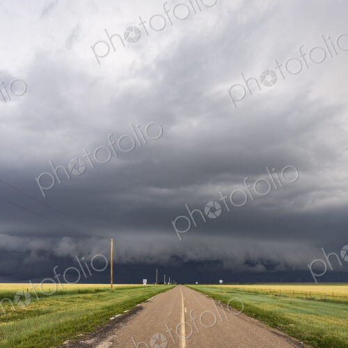 Developing Supercell storm on the horizon, black clouds at the end of a highway.