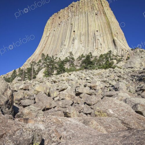 Devil's Tower National Monument rises dramatically above the rocky landscape in… Devil's Tower National Monument rises dramatically above the rocky landscape in…