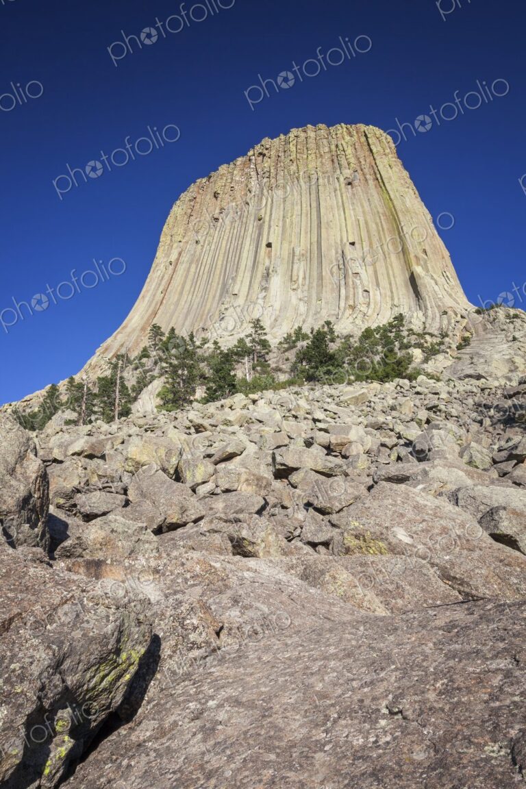 Devil's Tower National Monument rises dramatically above the rocky landscape in…