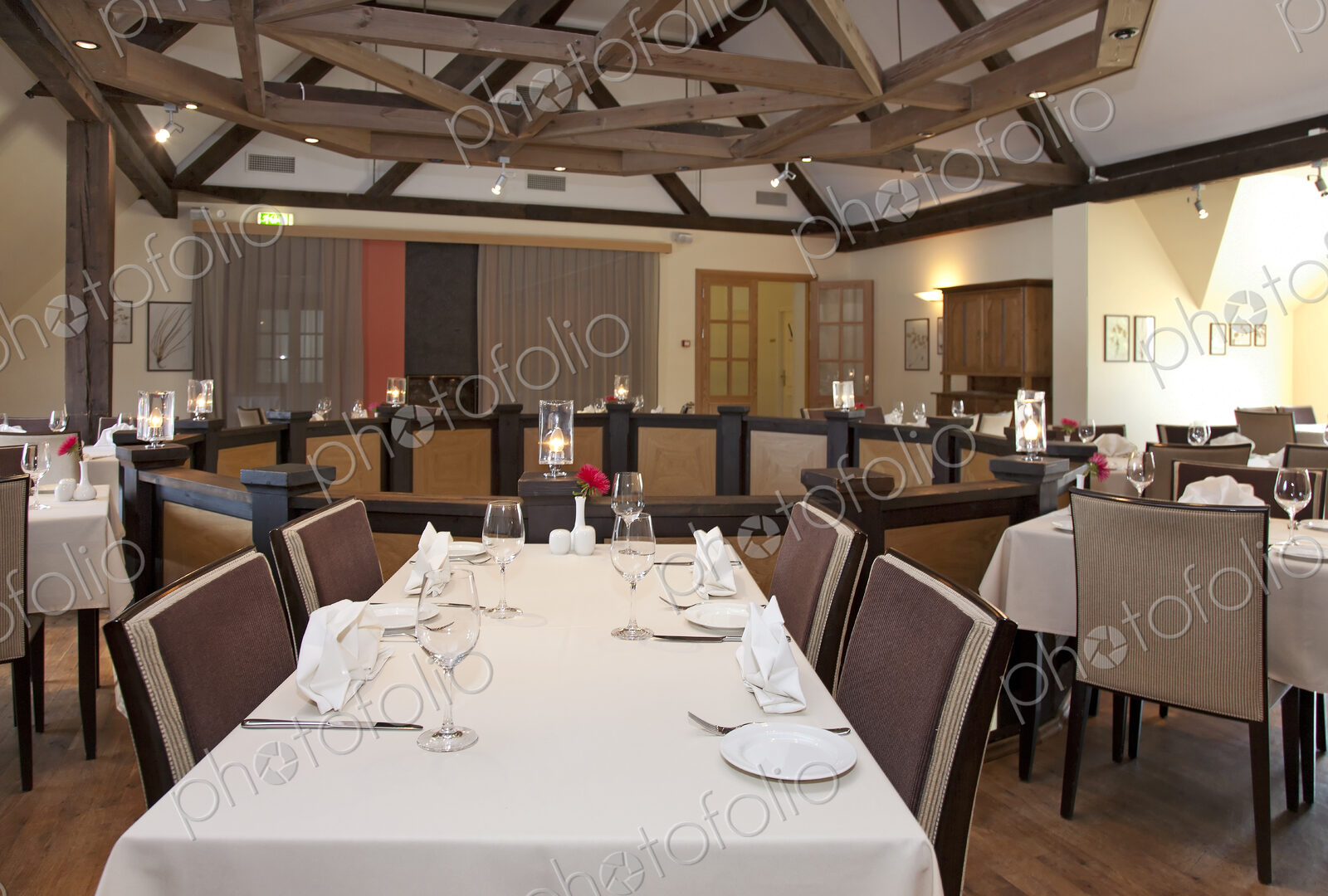Dining room, tables laid for dinner on a mezzanine floor, exposed beams and vaulted…