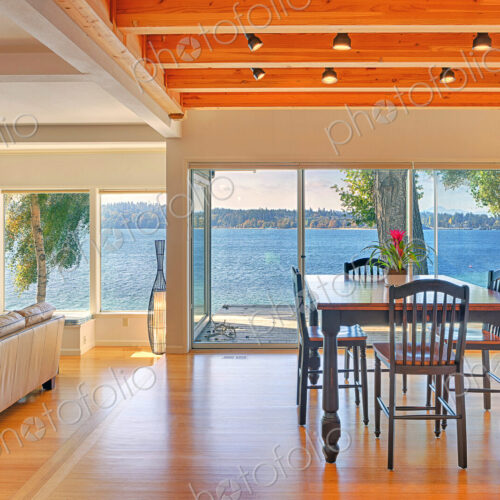 Dining table, sofa and glass walls in modern house