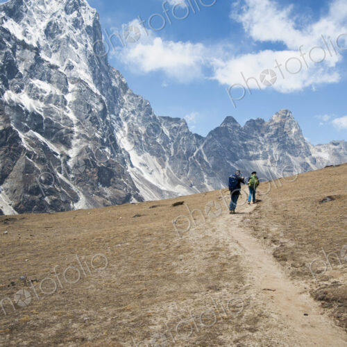Distant people hiking toward mountain, Pheriche, Khumbu region, Nepal Distant people hiking toward mountain, Pheriche, Khumbu region, Nepal