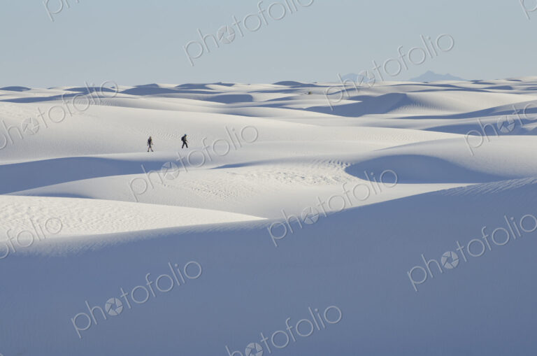 Distant people walking on snowy landscape