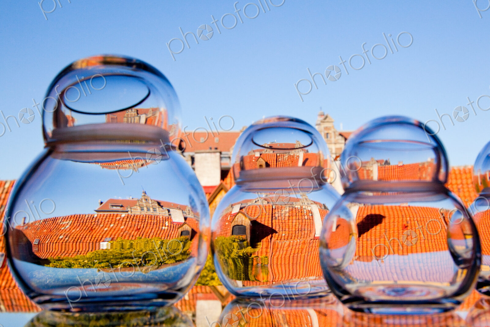 Distorted view through clear water in jars of the rooftops of the city.
