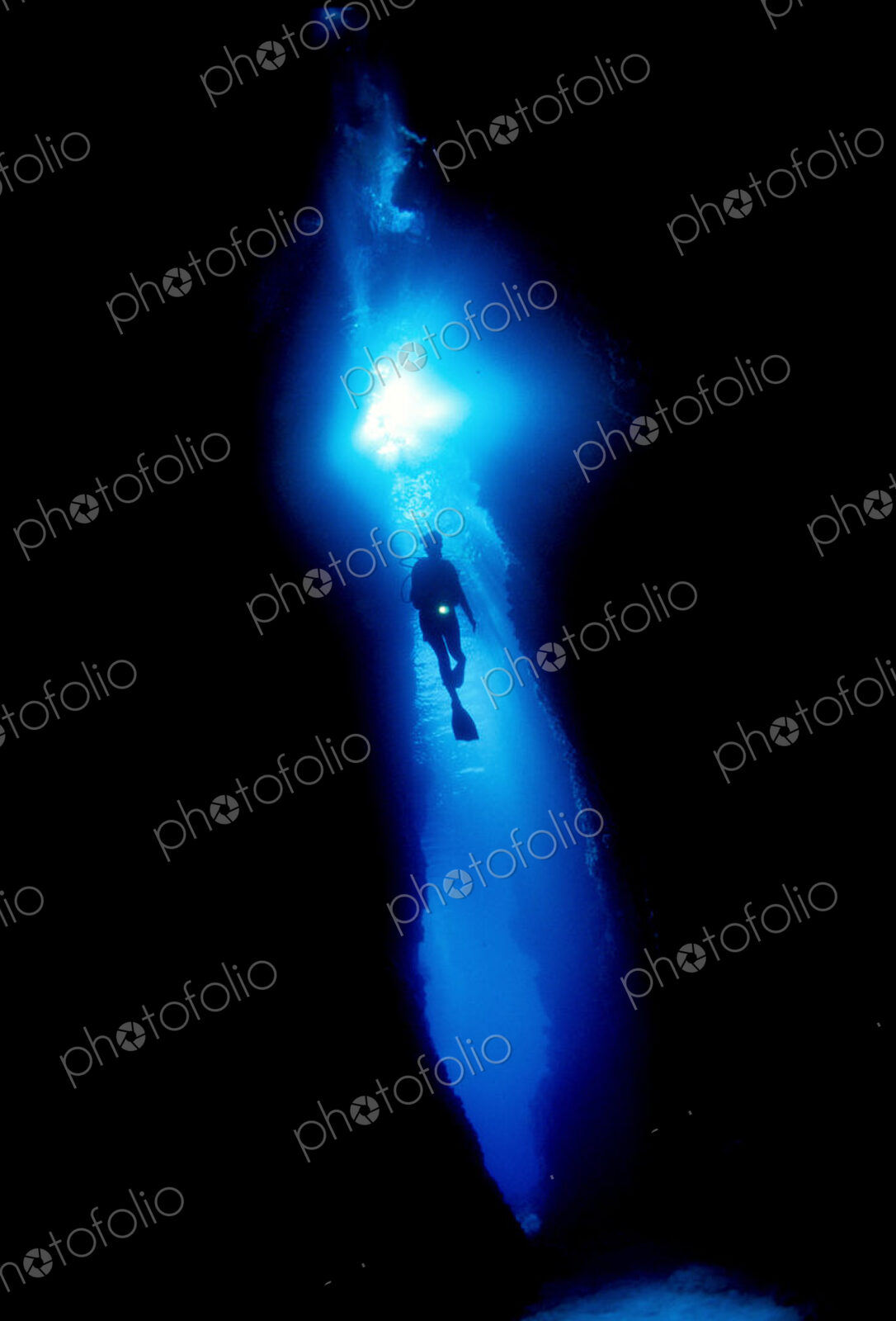 Diver silhouetted against the entrance to an underwater cave, Solomon Islands.
