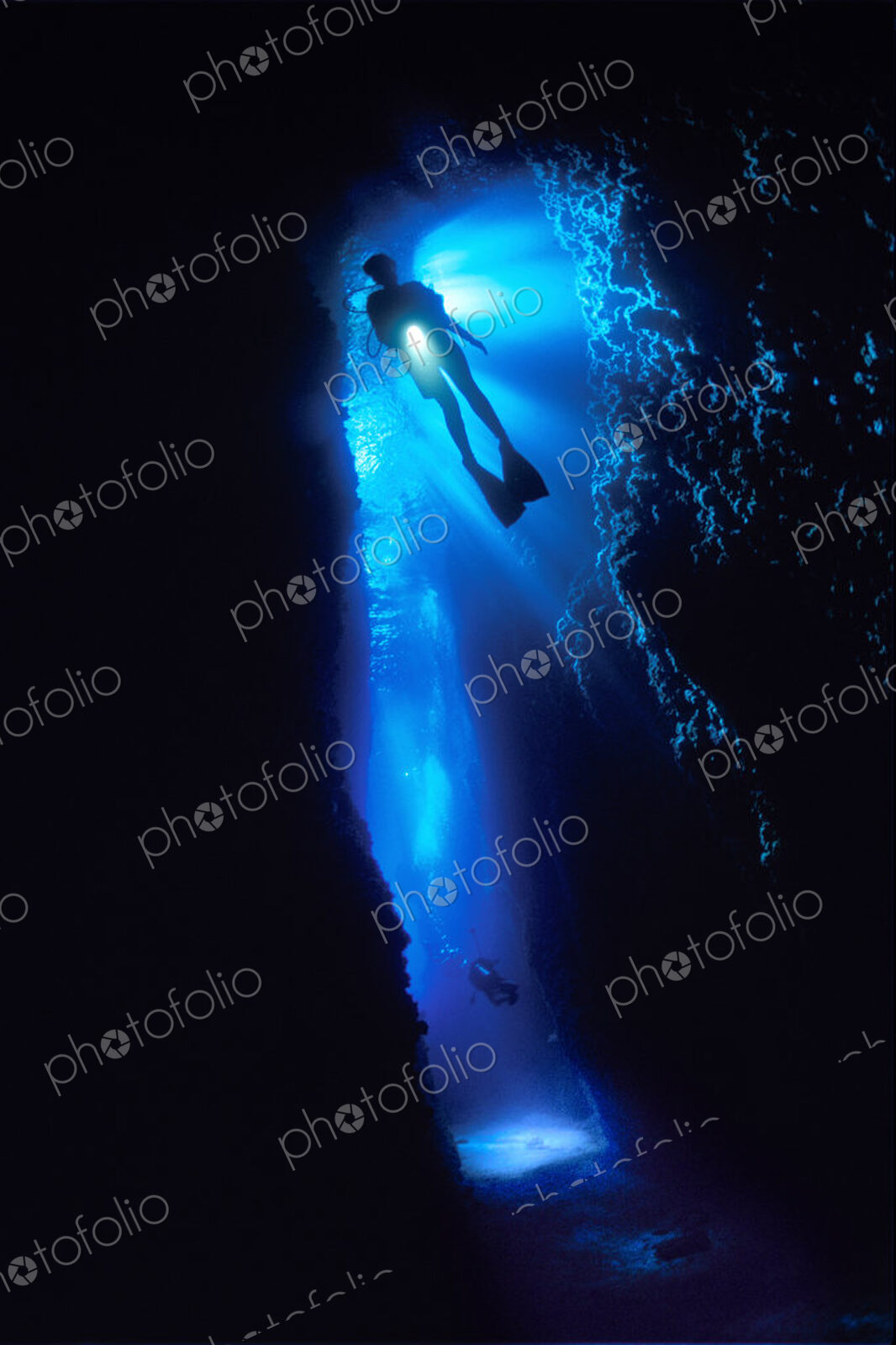 Diver silhouetted against the entrance to an underwater cave, Solomon Islands.