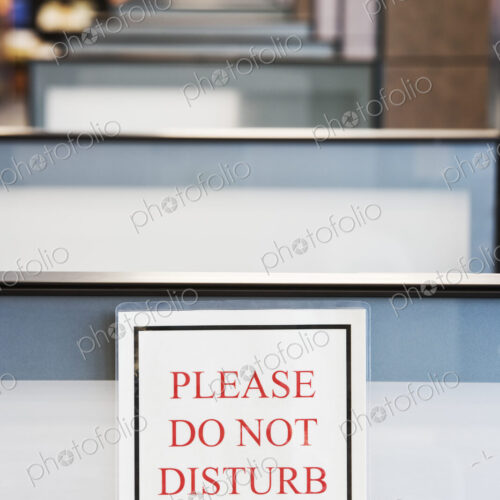 Do not disturb sign hung on the wall of a cubicle in an office.