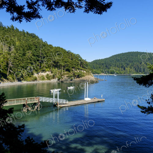 Dock in a bay surrounded by wooded hillsides.