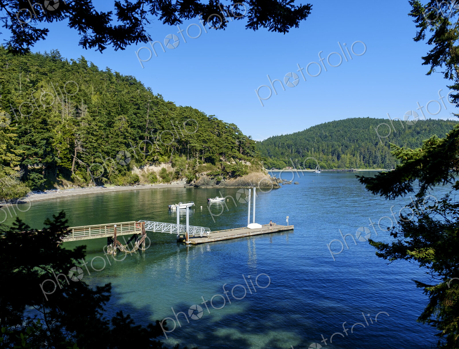 Dock in a bay surrounded by wooded hillsides.