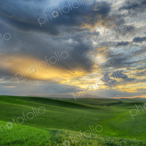 Dramatic sky over rolling hills in rural landscape Dramatic sky over rolling hills in rural landscape
