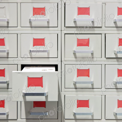 Drawers and red labels in an antique archive cabinet with index cards in a public library