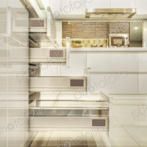 Drawers in a modern fitted kitchen with white doors and surfaces.