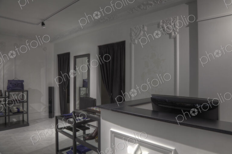 Dressing rooms and cash register behind empty store counter
