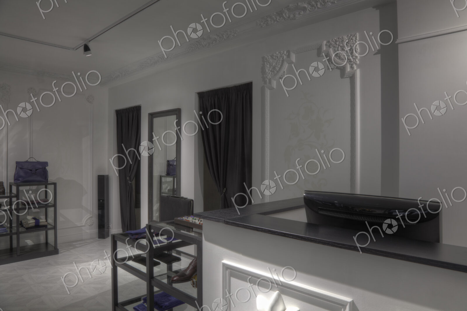 Dressing rooms and cash register behind empty store counter