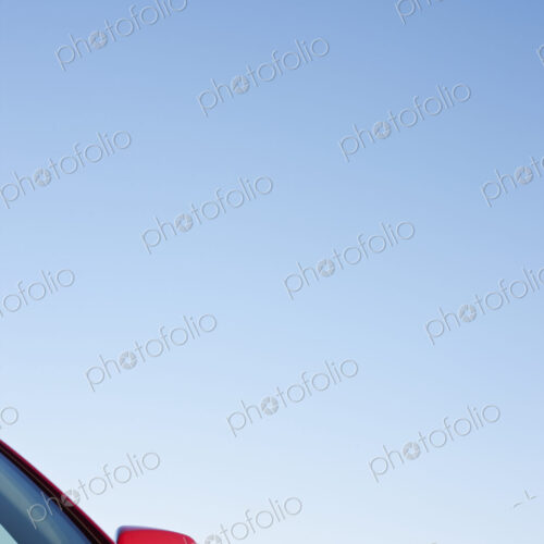 Driver Side Mirror and Hood of Red Car