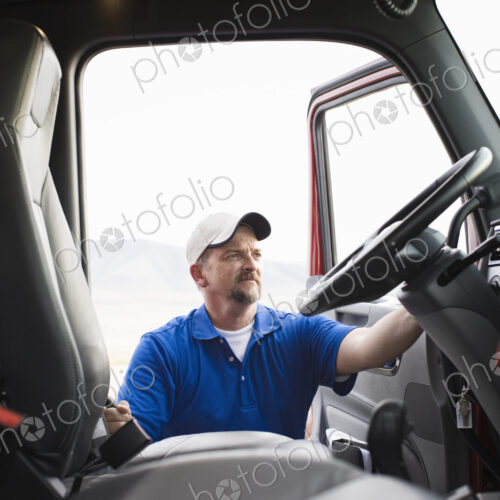 Driver getting into the cab of a commercial truck.