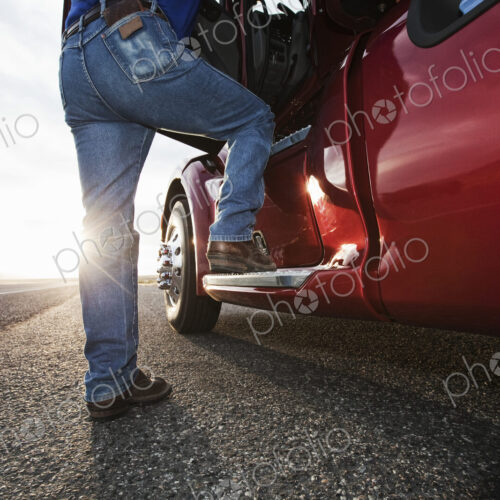Driver getting into the cab of a commercial truck. Driver getting into the cab of a commercial truck.