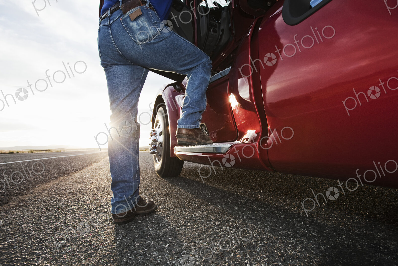 Driver getting into the cab of a commercial truck.