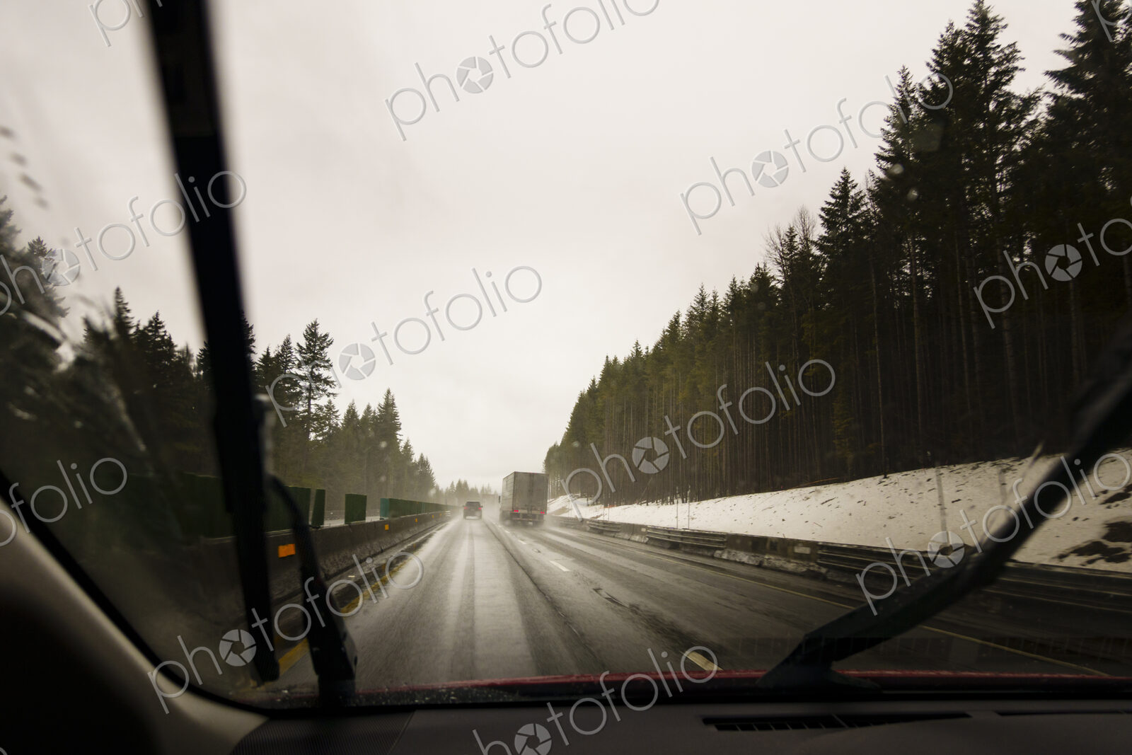 Driver’s perspective through windshield of winter highway with semi-truck.
