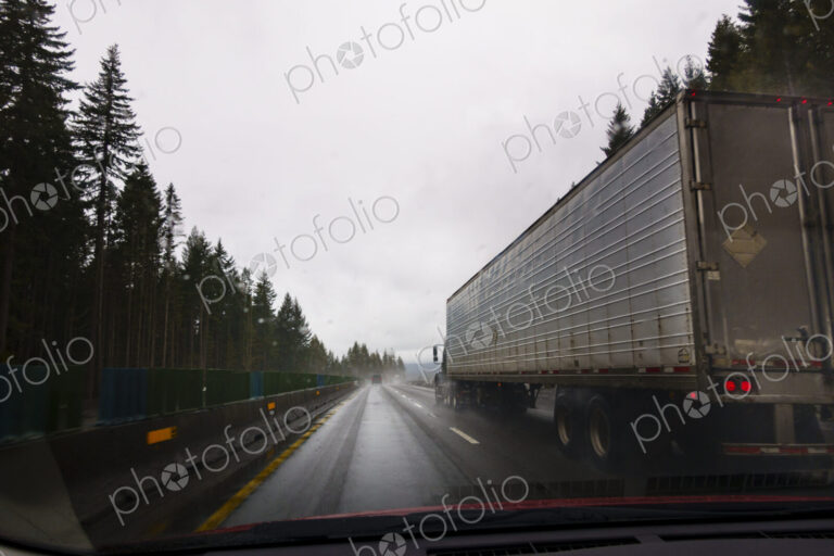 Driver's perspective through windshield of winter highway with semi-truck.