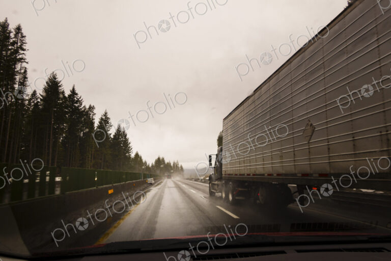 Driver's perspective through windshield of winter highway with semi-truck.