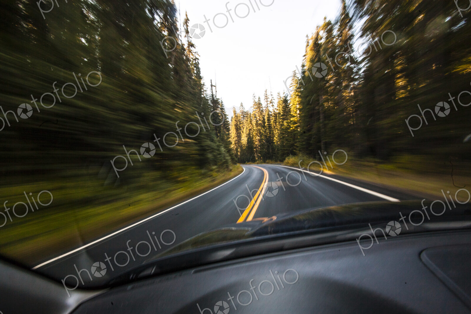 Driver’s pov through windshield speeding down two lane highway, Mount Rainier National…