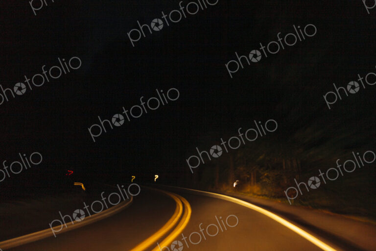 Driver's view of a highway road bend at night with limited visibility