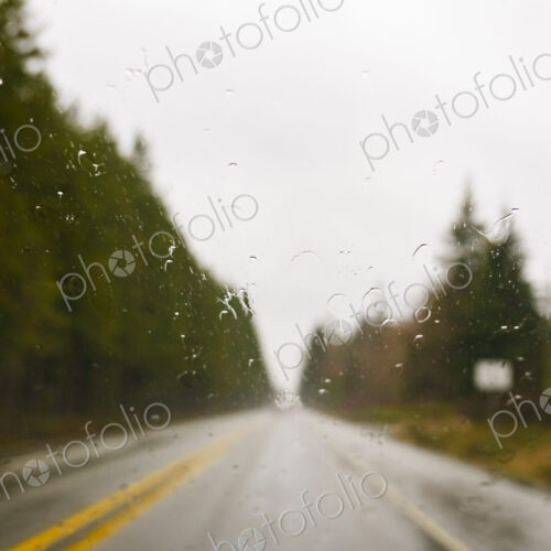Driver's view through windshield of wet highway in rural area, WA, USA
