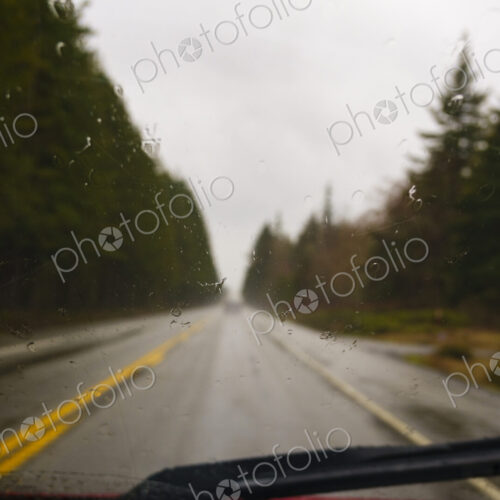 Driver's view through windshield of wet highway in rural area, WA, USA